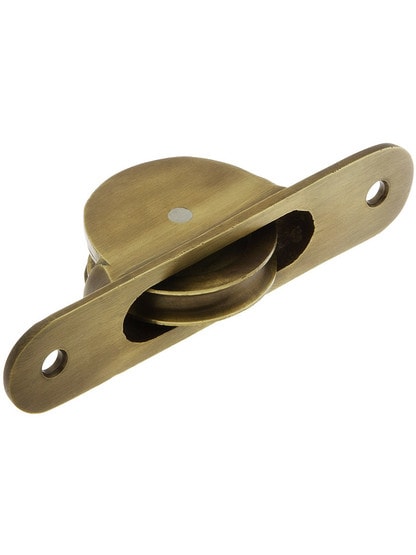 Cast Brass Radius End Sash Pulley With 1 3/4 inch Wheel in Antique Brass.